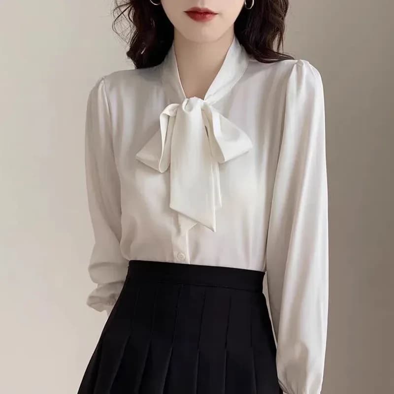 white satin tie neck bow blouse with a black skirt